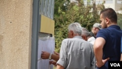 选民在库尔德自治区首府埃尔比勒的投票站外查找自己的名字 (2017年9月25日)