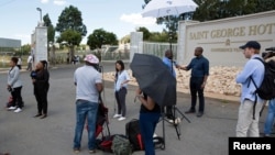 A member of the South African Police Services (SAPS) fires rubber bullets at rioters looting the Jabulani Mall in Soweto, southwest of Johannesburg.
