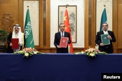 2023年3月10日在中国北京时任中共中央政治局委员、中央外事工作委员会办公室主任王毅会见伊朗最高国家安全委员会秘书沙姆哈尼和国务部长和沙特阿拉伯安全顾问穆萨德·本·穆罕默德·艾尔班