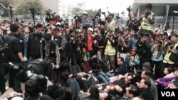 大批留守者手撓手半躺在地上等候警察拘捕(美國之音特約記者湯惠芸攝)