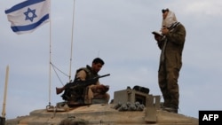 一名以色列士兵站在一輛位於以色列與黎巴嫩邊界地區的坦克上祈禱。（2023年10月30日）