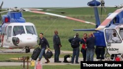 Workers disembark from a helicopter after being evacuated from oil production platforms ahead of Tropical Storm Cristobal, at Bristow Galliano Heliport in Galliano, La., June 6, 2020. 