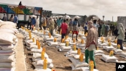 救援人員向難民營的災民派糧食。