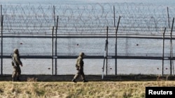 韓國士兵2013年4月7日在韓國首爾以北坡州沿著靠近分隔韓國和朝鮮的非軍事區的軍事圍欄巡邏