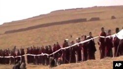 藏族喇嘛手持哈達給20多歲的自焚喇嘛彭措送葬(資料照片)