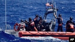 Экипаж судна «Оливер Генри» Береговой охраны США спасает трех моряков, которые оказались на мели на атолле Пайкелот, Федеративные Штаты Микронезии, 9 апреля 2024 года 