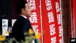 一名男子走過東京日本自民黨總部豎立的競選總裁的旗幟。 （2024年9月12日）