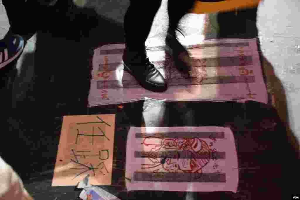 香港民主黨在維園年宵攤位的地上貼上兩塊惡搞梁振英抹地布。（美國之音湯惠芸攝）