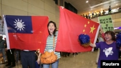親中國的台灣活動人士在桃園機場手舉中國和台灣旗幟歡迎大陸海協會會長張志軍訪問台灣。（2014年6月25日） 