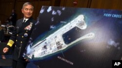 美國海軍上將哈里斯旁的照片顯示中國在永暑礁上施工（2015年9月17日）