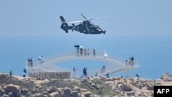 中國福建省平潭島上的遊客在觀看中國軍隊在台灣附近舉行的實彈軍演。（2022年8月4日）