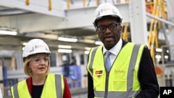 英國首相卓慧思（利茲·特拉斯）10月14日將她的財政大臣關浩霆（誇西·克沃滕）革職。圖為卓慧思和關浩霆2022年9月23日在一家工廠參觀。-美聯社資料照。