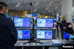 北京國際機場的工作人員正在使用熱掃描儀查看抵達乘客的體溫。（2020年1月25日）