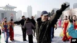 一批青年人星期三在北韓首都的平壤大劇場前跳舞慶祝火箭發射