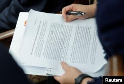 中方翻譯手拿習近平給特朗普信件的英文翻譯稿。