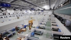 工人们正在把长春的一个展览中心改造成拥有1500张床位的临时医院。