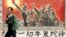 一名男子走過寧夏銀川街頭郊區的一處描寫中國文革的宣傳畫。（2007年4月25日）