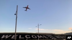 FILE - A sign painted near the runway of the Wellington International Airport greets travelers in Wellington, New Zealand, April 19, 2021. 