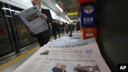 韩国首尔地铁报摊上出售的报纸头条是美国总统川普和朝鲜领导人金正恩计划举行峰会的报道。 （2018年3月10日）