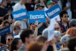 FILE - Supporters wave signs in support of Democratic presidential candidate Senator Bernie Sanders, as he speaks during a campaign rally in Denver, Colorado, Sept. 9, 2019.