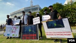 前香港眾志秘書長黃之鋒（右四）聯同多名抗爭派社運人士及多名被中國逮捕港人家屬，10月8日到飛行服務隊總部外抗議，他們展示據稱是飛行服務隊內部文件，質疑12港人事件是中港當局”勾結送中”。（美國之音湯惠芸拍攝）