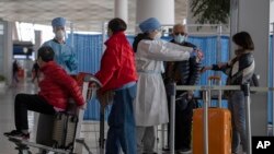 醫務人員在北京國際機場檢測從海外抵達的旅客體溫。 （2020年3月12日）