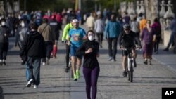 图为人们正在穿越西班牙马德里的托莱多大桥，周六，西班牙人能够外出锻炼，这是自封锁开始抗争以来的七周来的第一次。（2020年5月3日）