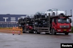 一輛大貨車運出特斯拉上海工廠出產的汽車。（2021年5月13日）