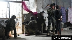 以色列国防军提供的这张照片显示，以色列伞兵在突袭叙利亚南部村庄贝特金时逮捕了一名通缉武装分子。(2025年11月28日)