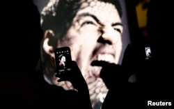 烏拉圭球星蘇亞雷斯被罰停賽﹐但是在巴西仍然有球迷對他支持﹐在廣告牌前舉機拍照。