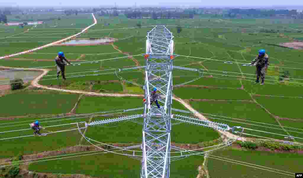 Workers check power lines during maintenance work in Laian, in China's eastern Anhui province.
