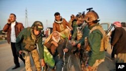 库尔德战士帮助一名被伊拉克基尔库克的“伊斯兰国”激进分子释放的雅兹迪老人。（资料照）