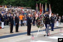 Vice President Mike Pence, center, pauses after placing a wreath in front of the Tomb of the Unknown Soldier in observance of Memorial Day, May 27, 2019, at Arlington National Cemetery in Arlington, Virginia.