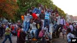 津巴布韦人在首都哈拉雷的议会大厦外听到穆加贝辞职的消息后欢呼雀跃。（2017年11月21日）