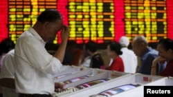 上海股民在股票交易所观看股市行情电子显示屏（2015年7月8日）