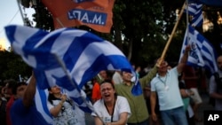 希腊公布了最新的全民公投结果之后，表示不接受债权人救助方案的人挥动希腊国旗。