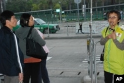 香港區議會選舉候選人的助選員(右一)向市民講解候選人的參選理念