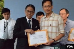 香港大學校委會主席梁智鴻(左)接收港大校友關注組召集人葉建源遞交的情願信。（美國之音湯惠芸攝）