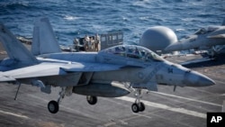 ເຮືອ​ບິນ​ລົບ FA-18 Super Hornet ບິນ​ລົງ​ຈອດ​ກຳ​ປັ່ນ​ບັນ​ທຸກ​ເຮືອ​ບິນ​ USS Ronald Reagan, 28 ຕຸ​ລາ 2015.(Kim Hong-Ji/Pool Photo via AP)