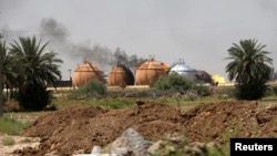 濃煙從伊拉克巴格達北部國營炊事氣廠的儲氣罐裡升起(2016年5月15日)