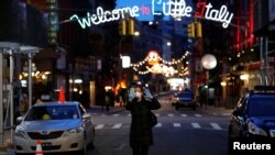 一名戴著口罩和手套的女子在曼哈頓街上行走。（2020年3月18日）