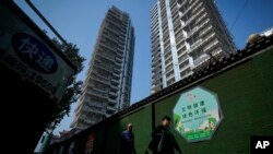 行人走過北京一處豪華住宅工地旁。 （2024年9月24日）