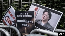 资料照：香港抗议者在北京驻香港机构中联办前手举铜锣湾书店失踪老板桂民海的照片。 （2016年1月19日）