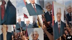 巴勒斯坦民族權力機構主席阿巴斯在聯合國發言後回國﹐巴勒斯坦人在約旦河西岸城市拉馬拉高舉他的畫像以英雄式歡迎。