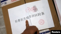 中國長春疾病控制中心的工作人員在召回的長春長生公司生產的狂犬病疫苗箱子上貼封條。（資料圖片）