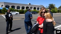 美国加州波威市的恰巴德犹太教堂发生枪击后，教堂外面，人们拥抱。