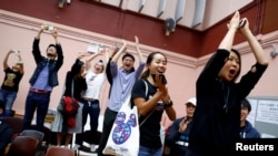 香港選民在他們支持的一名民主派候選人在區議會選舉中獲勝後鼓掌歡呼。（2019年11月25日） 