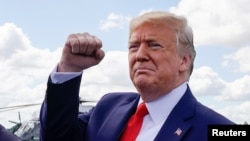 U.S. President Donald Trump pumps his fist as he arrives at Ocala International Airport in Ocala, Fla., Oct. 3, 2019.