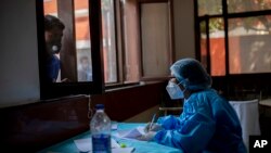 在印度首都新德里，一位醫護人員正在記錄新冠患者的名字。