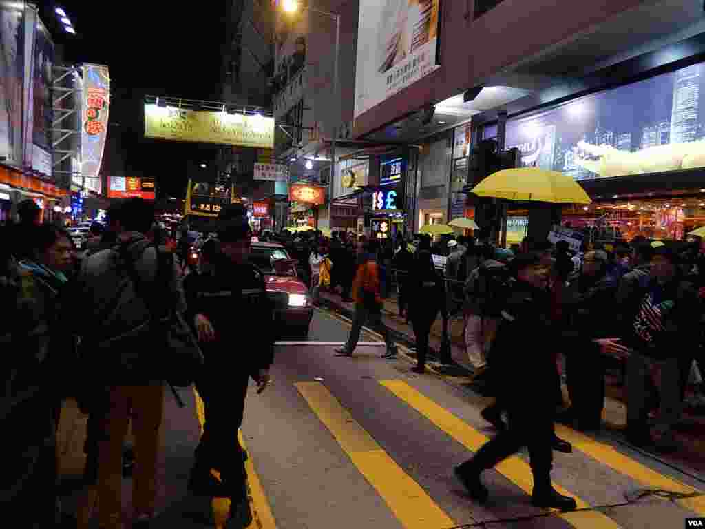 警員驅趕站在馬路上的「購物團」人士站回行人路上